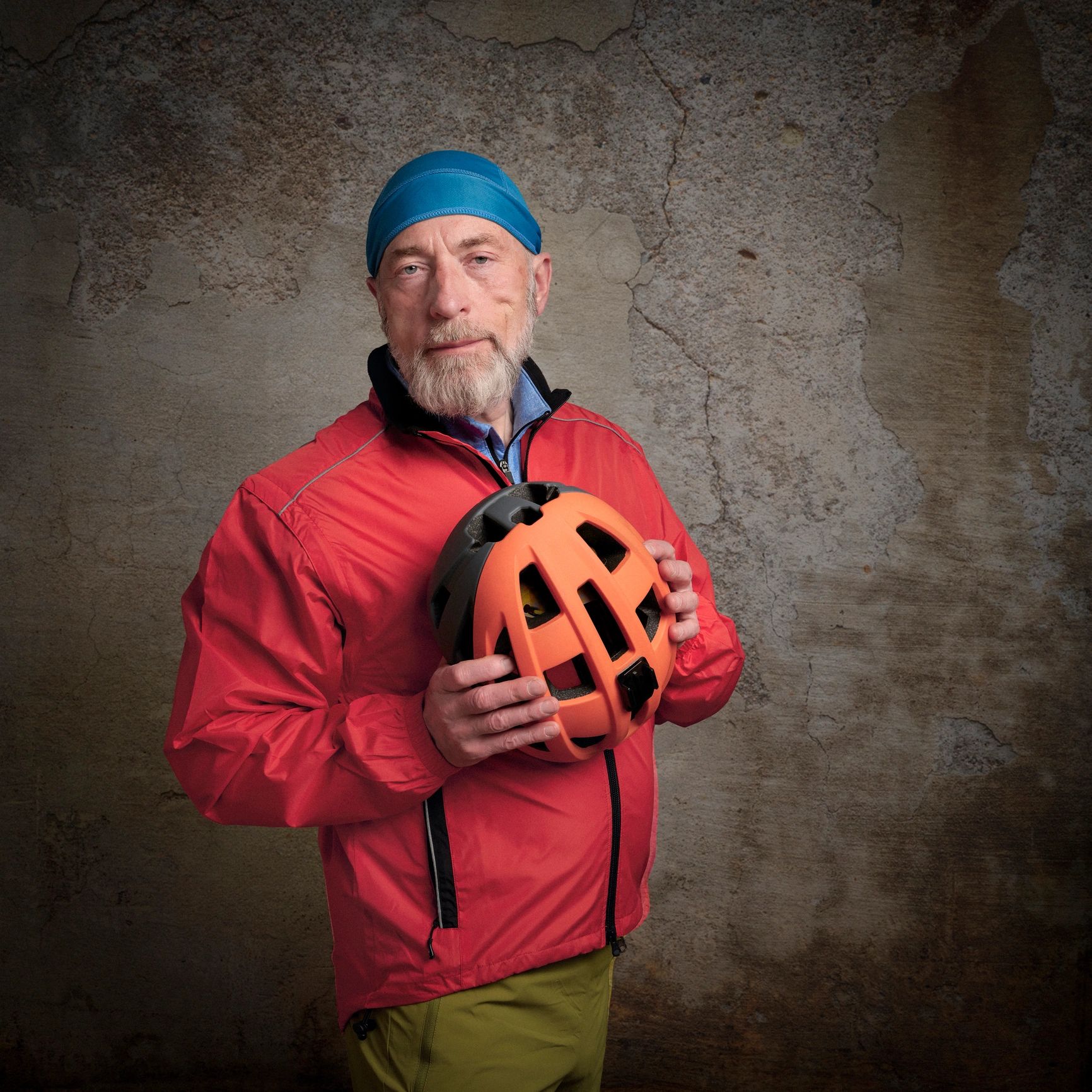 Portrait of a smiling cyclist holding a helmet